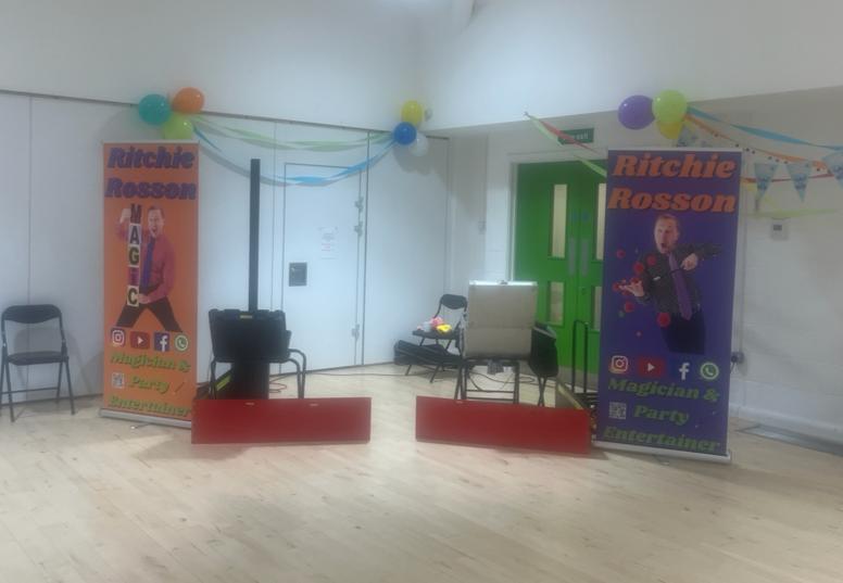Children's birthday party magician in hall. In a big venue, setting up in the corner is best. 